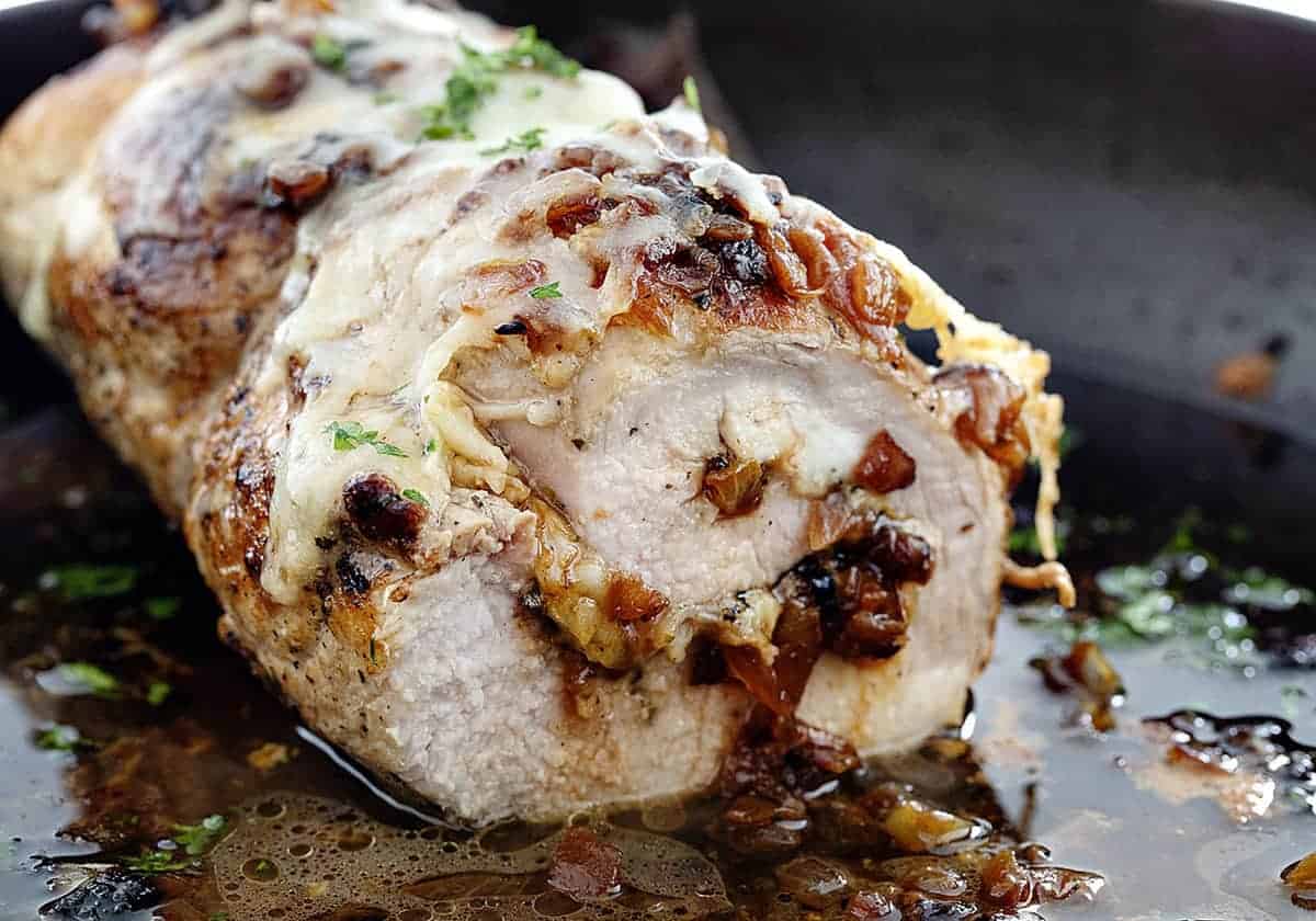 Melted cheese and perfectly caramelized onions are packed into this tender and juicy French Onion Stuffed Pork Loin. #frenchonionstuffedporkloin #porkloinrecipes #porkloin #porkrecipes #iamhomesteader #homesteadrecipes #iambaker #dinnerrecipes #frenchonion #gruyerecheese Cut into French Onion Stuffed Pork Loin in a Skillet