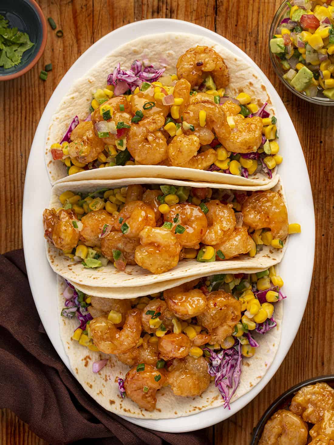 Bang Bang Shrimp Tacos are homemade bang bang shrimp topped with an easy-to-make cabbage slaw and folded in a homemade flour tortilla. Bang Bang Shrimp, Shrimp Recipes, How to Make Bang Bang Shrimp, Shrimp Tacos, Summer Food, BBQ, recipes, i am homesteader, iamhomesteader Overhead of Three Bang Bang Shrimp Tacos