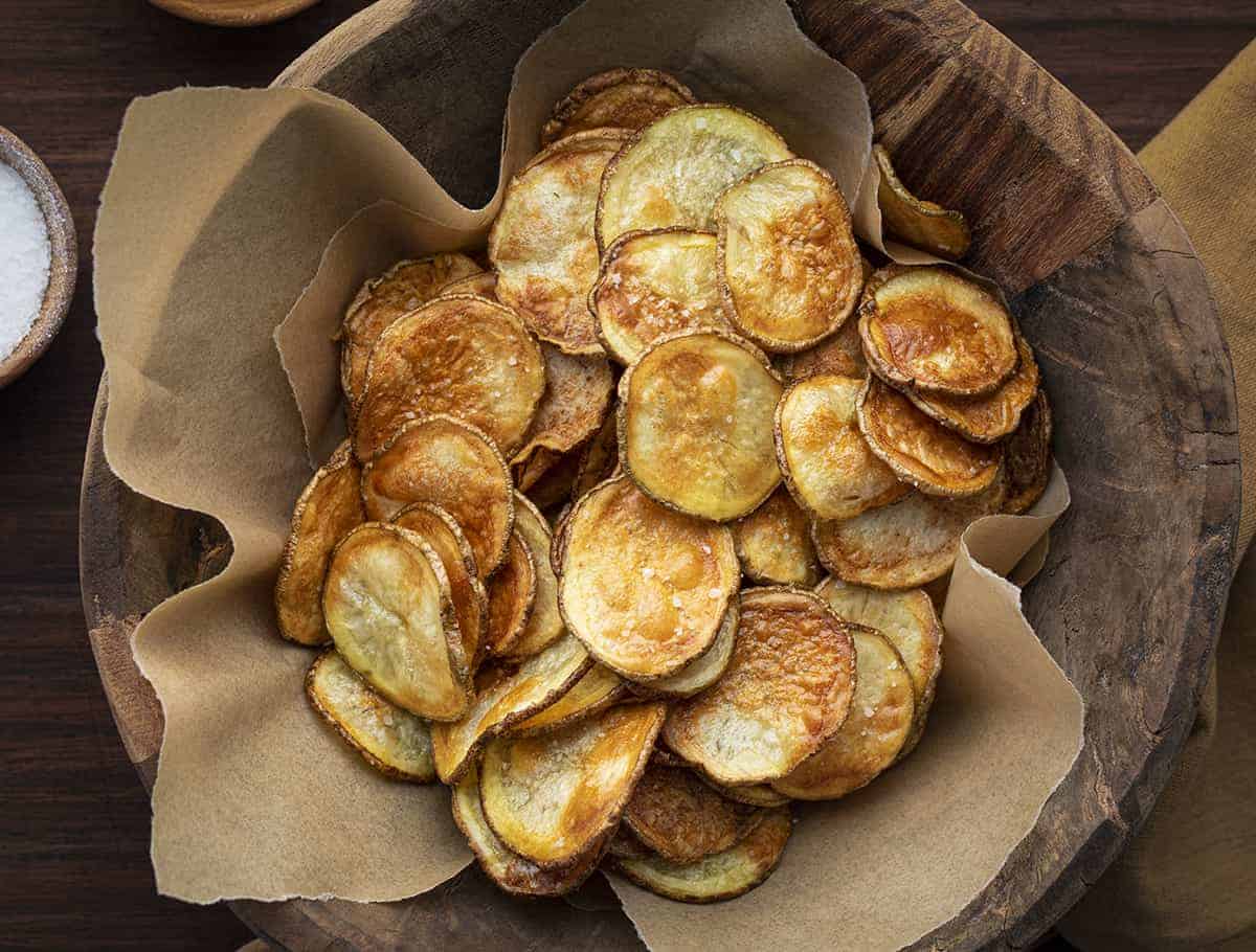 Homemade Potato Chips are crispy chips made with russet potatoes, seasoned with a little salt, and baked in the oven for a healthier potato chip. Oven Baked Potato chips, how to make potato chips, homemade potato chips, potato chip recipe, appetizer, recipes, i am homesteader, iamhomesteader Potato Chips in a Bowl