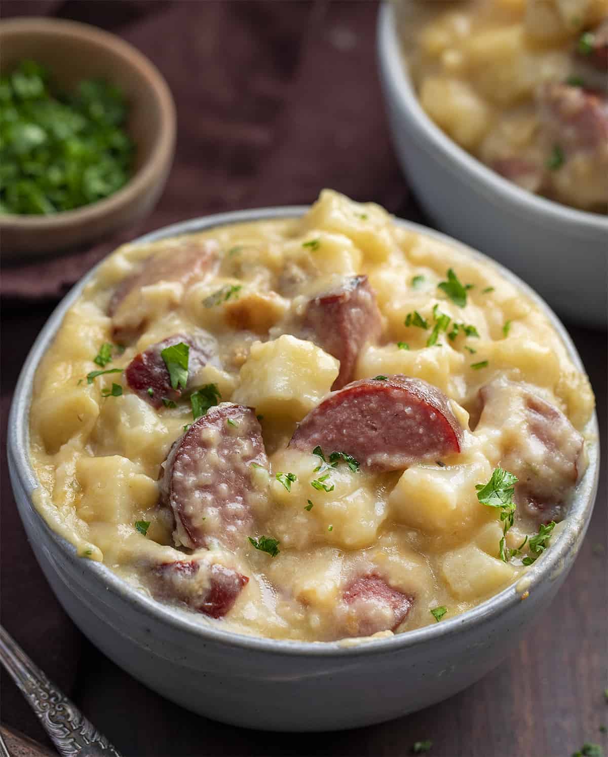 Slow Cooker Kielbasa and Potatoes is as easy to put together as it is flavorful, made with kielbasa, potatoes, cream of chicken soup, and cheese, all cooked together in a slow cooker. Ring Sausage recipes, dinner, supper, easy dinner, cheap dinner recipes, budget friendly recipes, savory, recipes, kielbasa recipes, i am homesteader, iamhomesteader Bowls of Slow Cooker Kielbasa and Potatoes