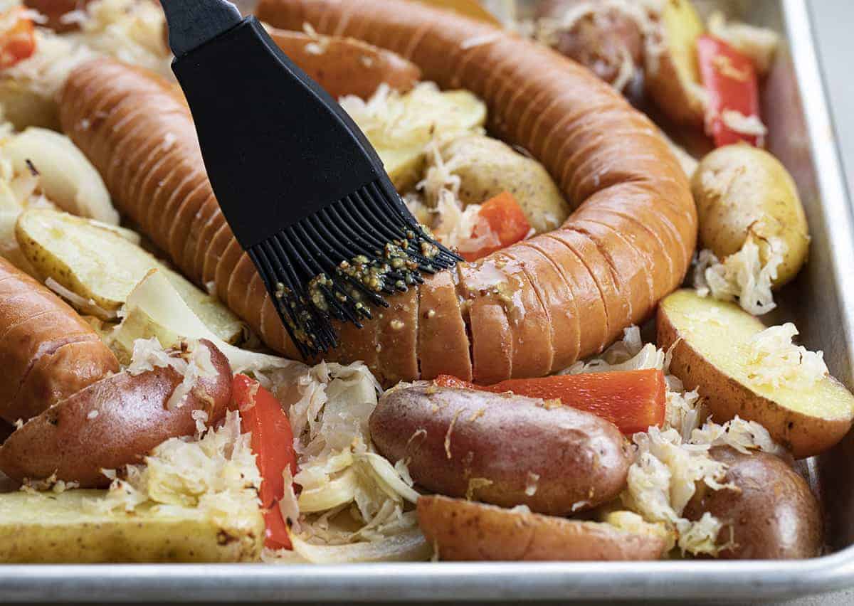 Adding Sauce to Hasselback Kielbasa Sheet Pan Dinner