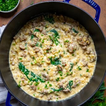 One Pot Sausage Orzo on a wooden table from overhead.