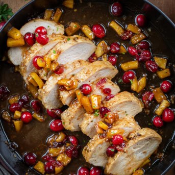 Sliced Cranberry Apple Pork Tenderloin in a black skillet from overhead.