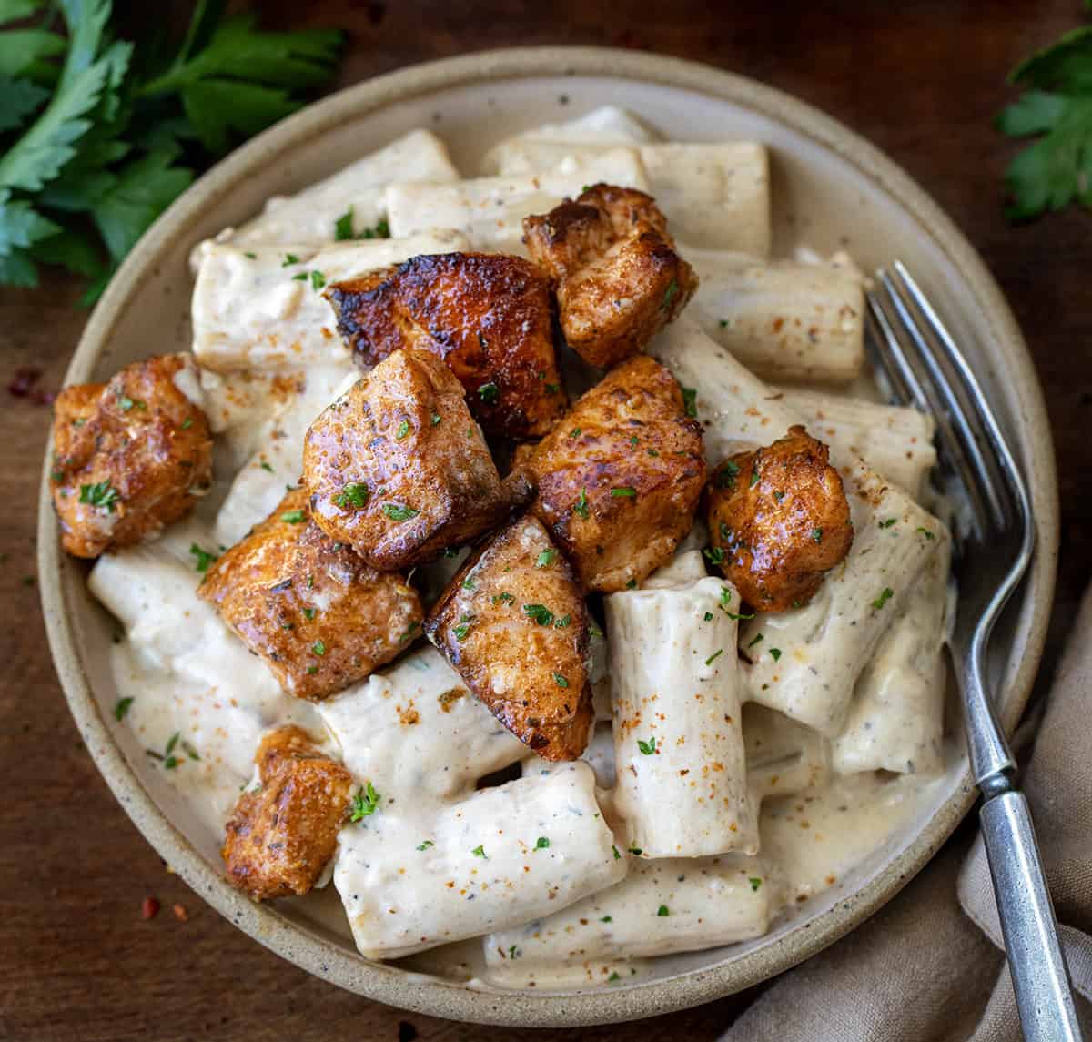 Plate of Cajun Salmon Rigatoni with a fork very close up.