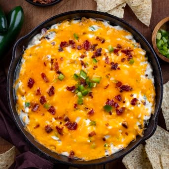 Chicken Jalapeño Popper Dip in a skillet on a wooden table from overhead.