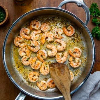 Skillet of Cowboy Butter Shrimp Scampi on a wooden table from overhead.