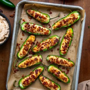 Pan of Cowboy Jalapeño Poppers on a wooden table from overhead.