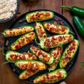 Pan of Cowboy Jalapeño Poppers on a wooden table from overhead.